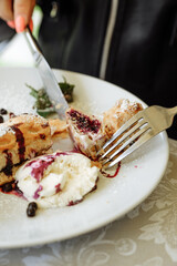 Delicious dessert being cut with a knife and fork on a white plate.