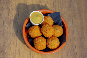Bitterballen, Dutch meat-based snack in white plate served with mustard on wooden tabel background, Typically containing a mixture of beef or veal, Bitterballen are one of Holland's favorite snacks.