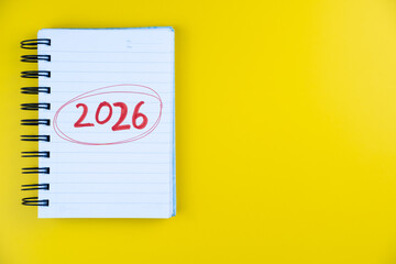 Notepad with 2026 written in red circle on notebook page, new year goals, planning and future...