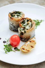 Delicious stuffed fish rolls with fresh ingredients on a white plate.