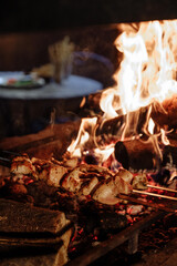 Grilled chicken skewers over a roaring fire