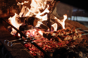 Grilled meat on skewers over a burning campfire