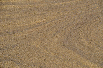 A detailed, abstract close-up of the textured, rippled surface of a wastewater treatment pond. The colors and patterns highlight a specific industrial process.