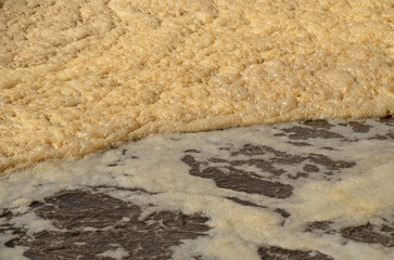 A detailed and abstract view of foamy water in an aeration tank at a wastewater treatment plant. The image represents the biological processes of water purification.