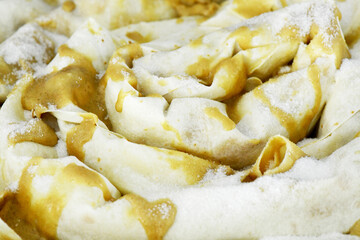 A close-up of a traditional uncooked tahinli pita, or tahini pie, with its beautiful spiral dough layers. The image shows the delicate details of the pastry before it is baked.