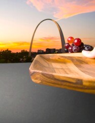 Wooden platter with grapes, Gateway Arch sunset backdrop