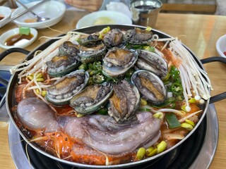 동그란 냄비에 담긴 맛있는 콩나물과 전복, 낙지,새우 해물탕 