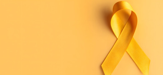 Yellow ribbon on flat yellow background, symbolizing cancer awareness with copy space for health campaigns and design use
