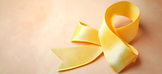 Yellow ribbon on flat yellow background, symbolizing cancer awareness with copy space for health campaigns and design use
