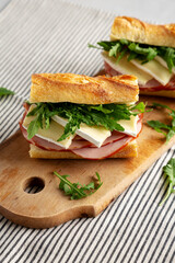 Homemade French Ham and Brie Baguette with Arugula Greens, side view.