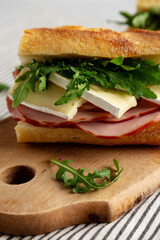Homemade French Ham and Brie Baguette with Arugula Greens, side view. Close-up.