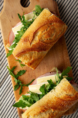 Homemade French Ham and Brie Baguette with Arugula Greens, top view. Close-up.