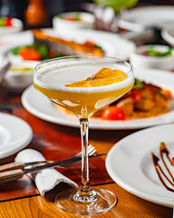 Cocktail against the background of food and table in the restaurant
