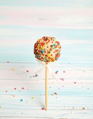 Sweet, round cake pop with sprinkles on a stick