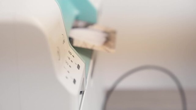 A person is using a injet laser printer and a laptop printing a photos