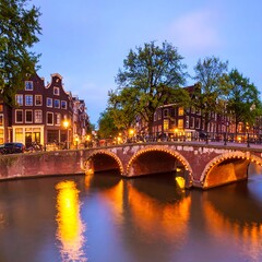 Obraz premium Dutch canal scene at dusk, with illuminated bridge and buildings