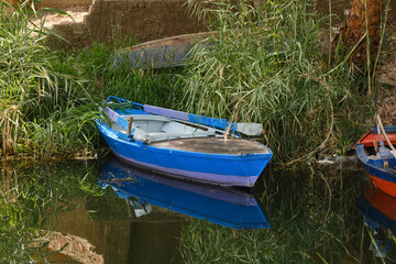 Blue boat with oars on the shore on the Nile River in Egypt