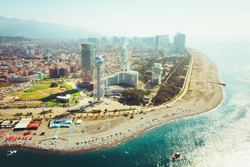 Aerial panoramic view Batumi cityscape with beach and promenade attractions, tourist in sunny summer day. Popular Georgia black sea coastline city holiday destination