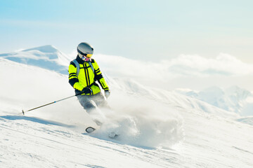 Freerider skier carving powder turn with snow spray swirls on sunny mountain slope in alps