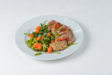 tuna in sesame in a white plate on a white background macro photo