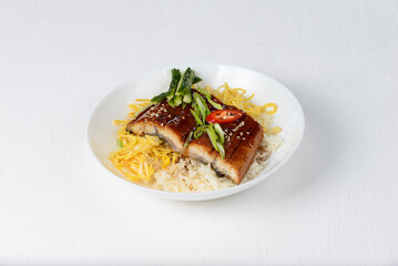 white rice with fish and vegetables in a white plate on a white background