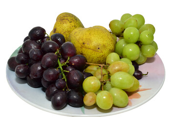 On a ceramic dish lie ripe and juicy fruits such as grapes and pears.