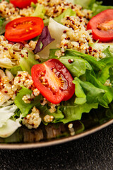 Quinoa salad tomato, green leaf salad vegetables dish natural product tasty snack fresh gourmet food background on the table rustic top view copy space keto and paleo diet vegan and vegan food