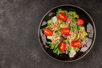 Quinoa salad tomato, green leaf salad vegetables dish natural product tasty snack fresh gourmet food background on the table rustic top view copy space keto and paleo diet vegan and vegan food