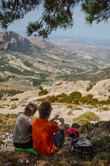 Hikers Resting on Mountain Overlook with Scenic Valley View