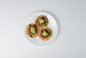 tacos with veal on a white plate on a white background macro photo