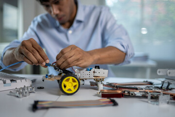 Engineer connecting cable to robot prototype in modern laboratory