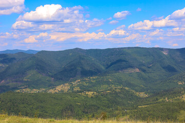 Endless mountain slopes covered with green forests create an impressive landscape that conveys the peace and grandeur of nature.