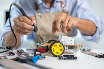 Engineer soldering components on a robot prototype in modern laboratory