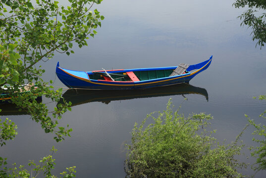 Typical fishing boat, tied up on the River Tagus in the picturesque town of Constancia where the Zezere River flows into the Tagus - 'Tejo' in Portuguese. Tomar, Santarem district, Ribatejo, Portugal.