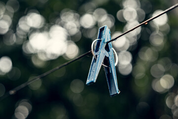 Blue Clothespin Hanging on a Wire with Bokeh Background