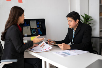 Business people discussing charts and graphs on computer screen and documents