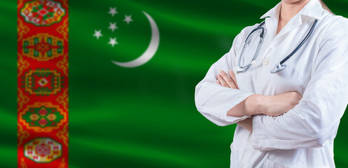 Doctor with crossed arms on Turkmenistan flag. Turkmen health and care concept. Female doctor on...