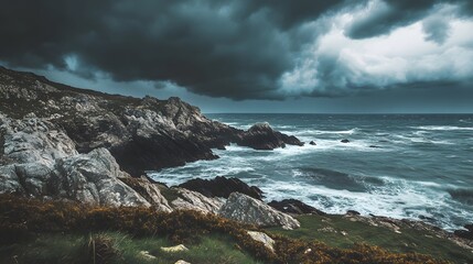 Obraz premium Dramatic coastal landscape with dark storm clouds looming over rocky shore and turbulent waves crashing