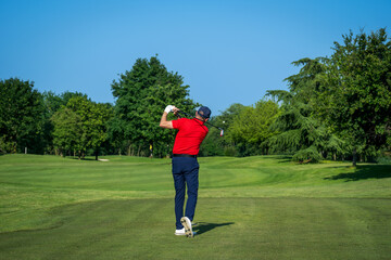 Obraz premium Golfer performing swing on a sunny day at the golf course