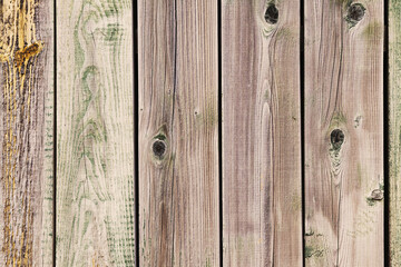 Close up of aged wooden planks showing signs of weathering and wear, creating a rustic and textured background