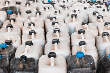 Many plastic containers are storing chemicals, forming a repetitive pattern in an industrial setting