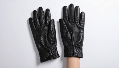 A pair of black leather gloves with gathered wrists rests on a white surface—evoking tactile elegance, protective form, and the quiet symbolism of winter fashion and human gesture.