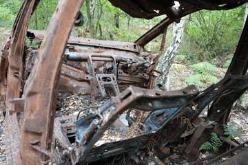 Discover a rusted car wreck surrounded by woodland at Strawberry Hill Heath in Mansfield, Nottinghamshire, England, offering a glimpse of the countryside's history and nature.