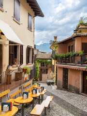 Charming cobblestone alley in Malcesine, Italy, lined with colorful houses, flower pots, and balconies draped in greenery. A peaceful, picturesque glimpse of traditional Italian village life.