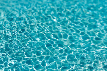 Background of rippled pattern of clean water in a blue swimming pool
