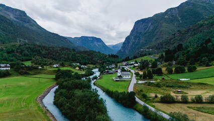 Breathtaking landscape of Fortun in Norway, showcasing a serene river winding through vibrant fields and mountains. Perfect scene for lovers of nature and tranquility amidst stunning scenery.