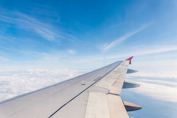 Fototapeta premium View from the airplane window at a beautiful cloudy sky and the airplane wing
