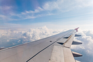 Obraz premium View from the airplane window at a beautiful cloudy sky and the airplane wing