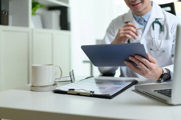 Obraz premium Close-up of a confident male doctor hands using technology for a virtual check-up, showcasing modern healthcare and digital diagnosis