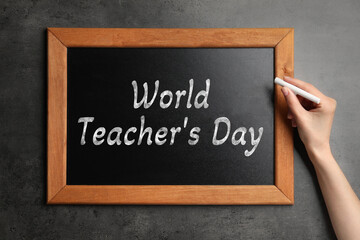 Happy Teacher's Day greeting card. Woman writing text on small blackboard, closeup